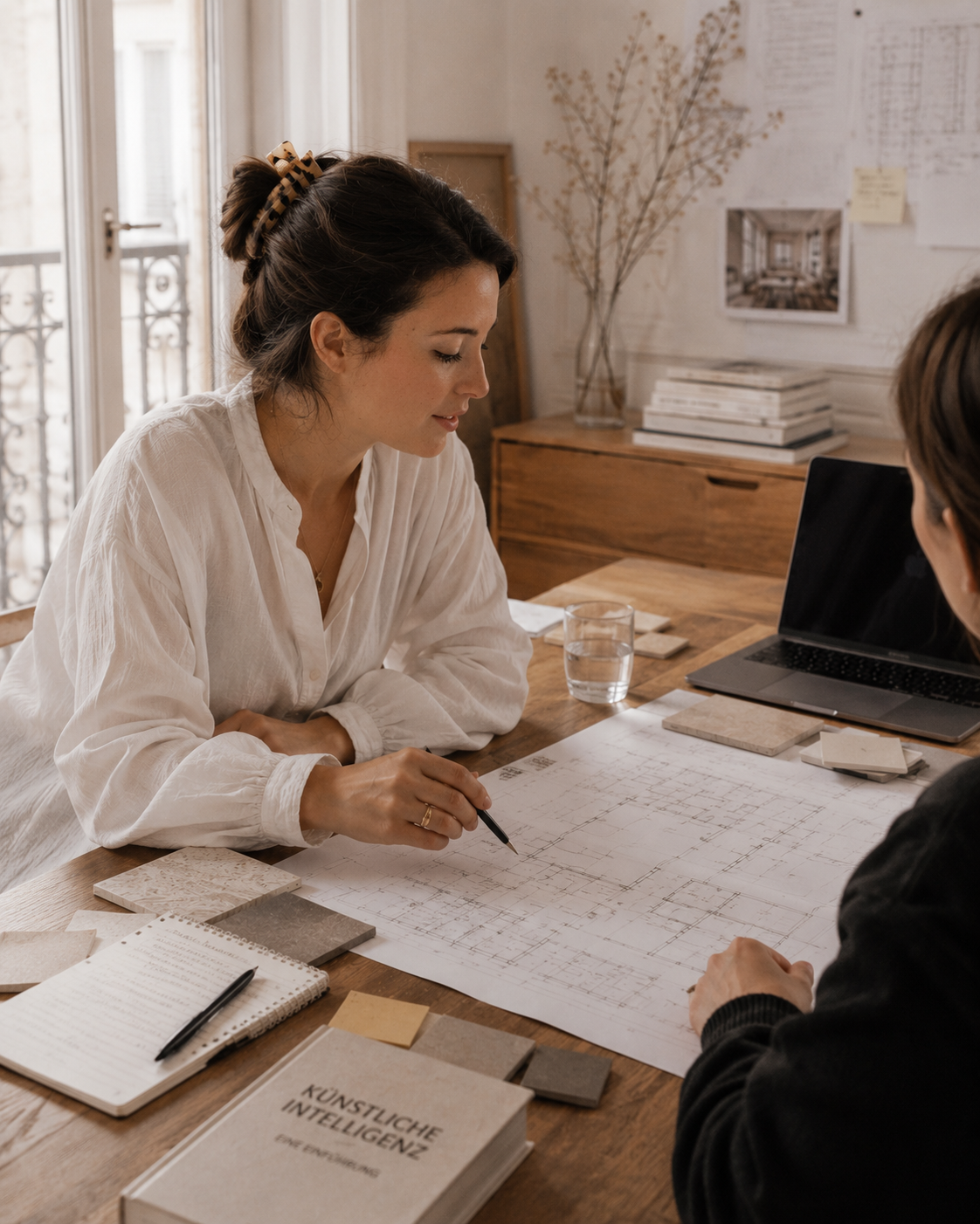 Architektin arbeitet an einem Grundriss am Holztisch